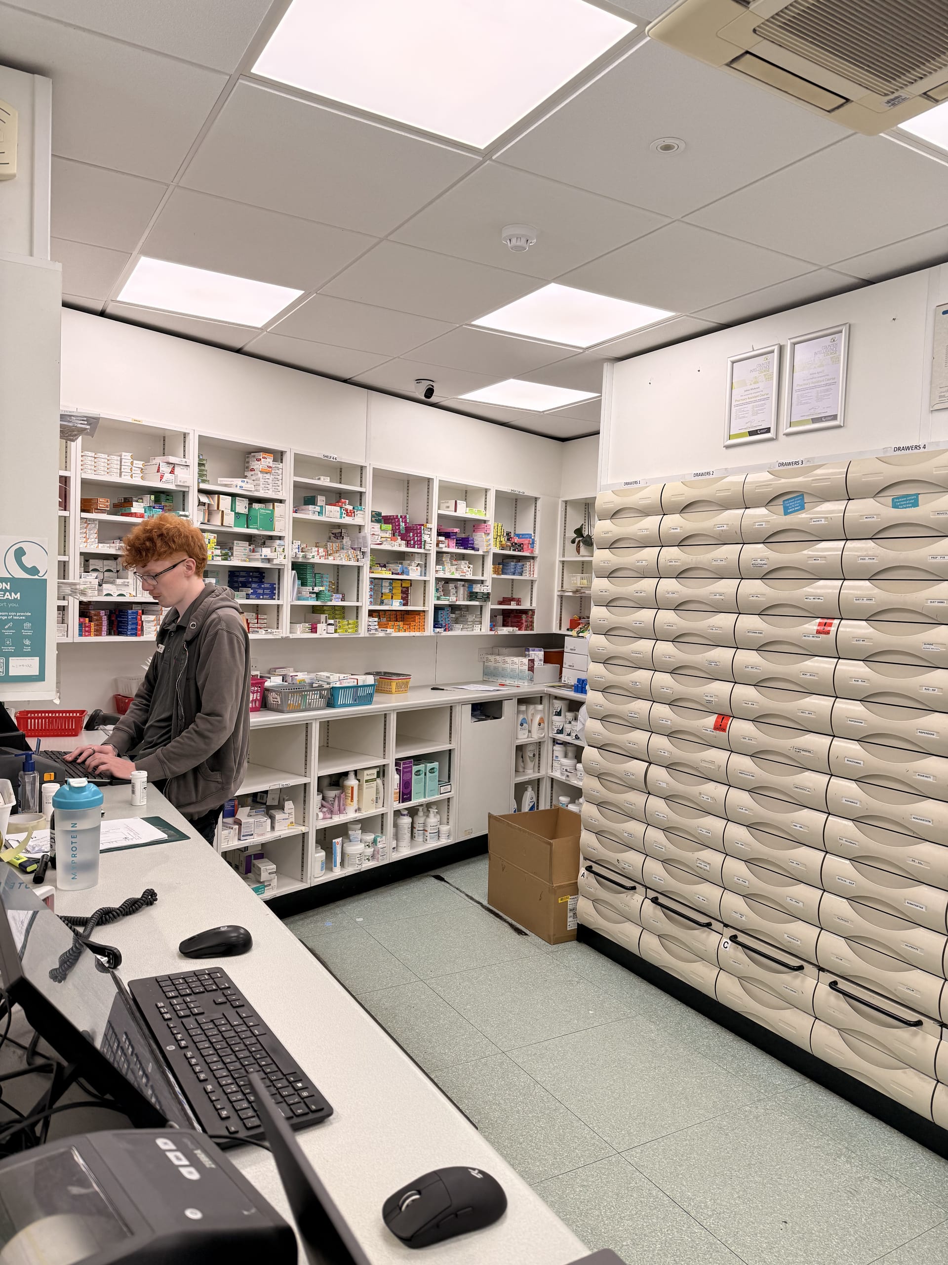 Inside the Medicine Stop dispensary: a pharmacy team member working with the automated medicine storage system.